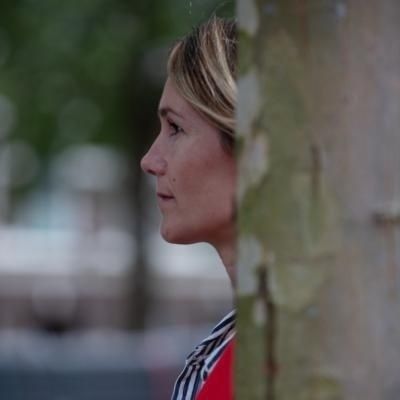 vrouw achter boom